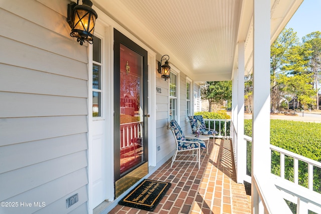 view of exterior entry featuring covered porch