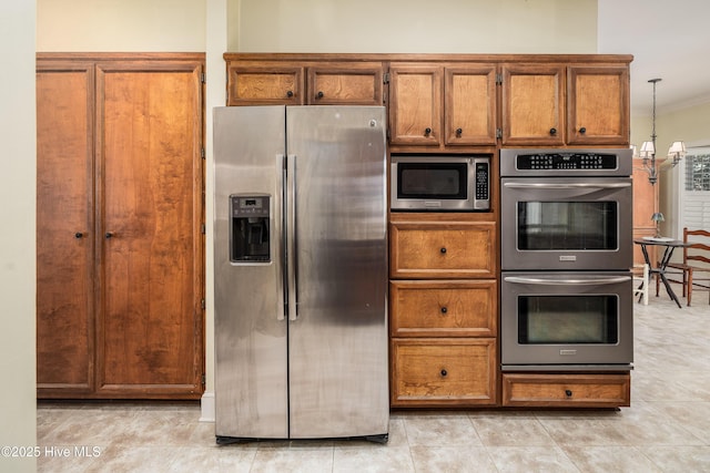 kitchen featuring appliances with stainless steel finishes, brown cabinets, and crown molding