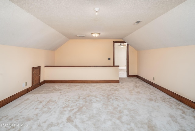 additional living space featuring visible vents, a textured ceiling, and carpet flooring