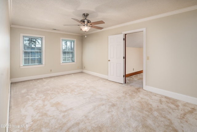 carpeted empty room with ornamental molding, a textured ceiling, baseboards, and a ceiling fan