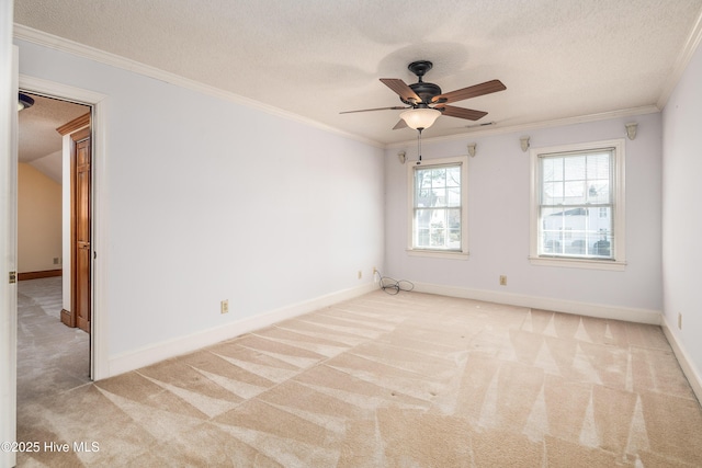 spare room featuring carpet floors, ornamental molding, a textured ceiling, and baseboards