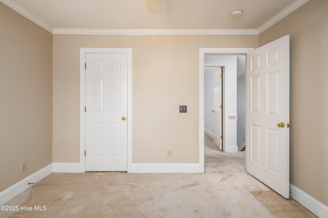 unfurnished bedroom featuring carpet flooring, crown molding, and baseboards