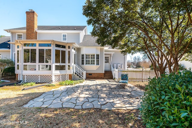 back of property featuring a sunroom, a chimney, roof with shingles, crawl space, and fence