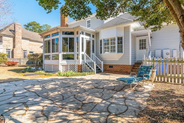 back of property featuring a sunroom, crawl space, fence, and a chimney