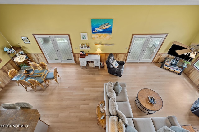 living area featuring a wainscoted wall and wood finished floors