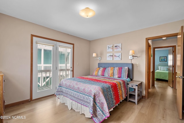 bedroom featuring access to outside, baseboards, and wood finished floors