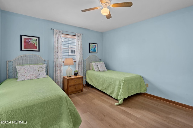 bedroom featuring ceiling fan, baseboards, and wood finished floors