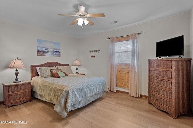 bedroom with light wood-style floors, visible vents, ceiling fan, and baseboards