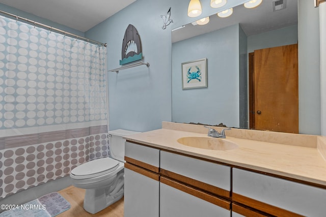 bathroom with visible vents, a shower with shower curtain, toilet, wood finished floors, and vanity