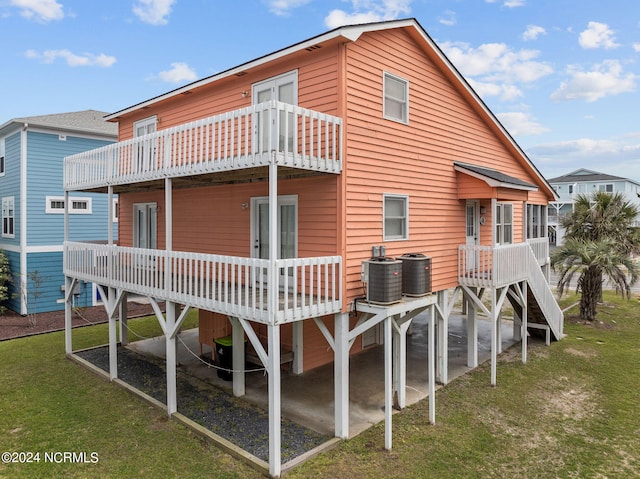 rear view of house featuring a wooden deck, central AC unit, and a yard