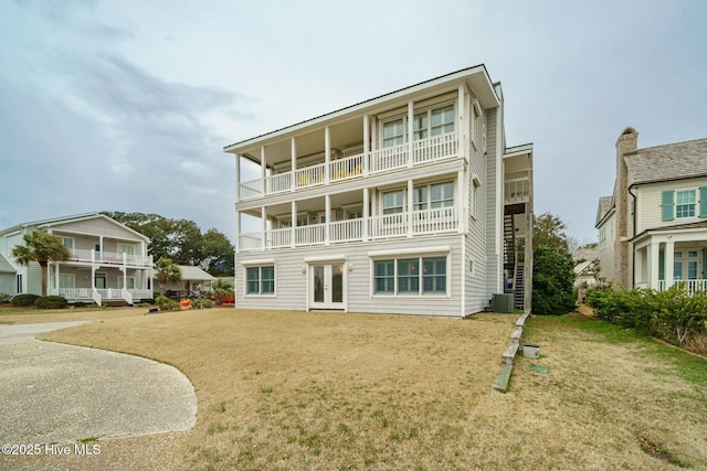 back of property featuring central AC, french doors, and a lawn