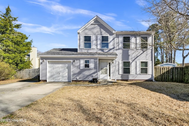 traditional-style house featuring fence, a garage, and driveway