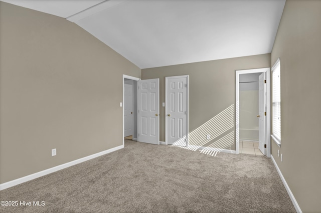 spare room with lofted ceiling, carpet, and baseboards