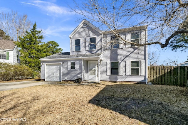 traditional-style home with a garage, concrete driveway, and fence