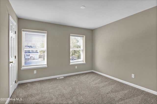 carpeted empty room with baseboards and visible vents