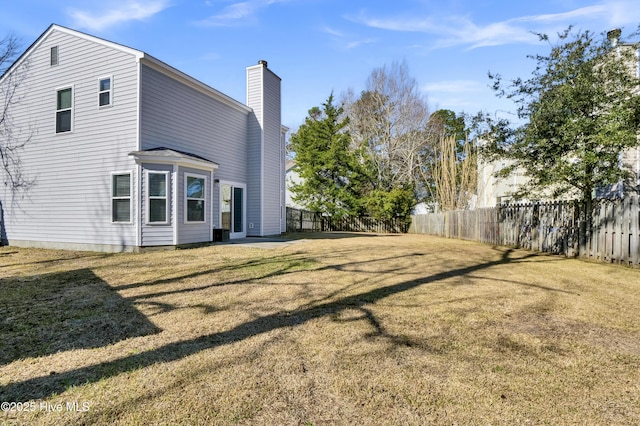 exterior space featuring a yard, a chimney, and fence