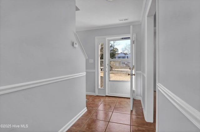 entryway with ornamental molding, tile patterned flooring, visible vents, and baseboards