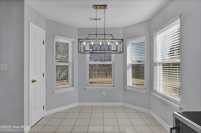 unfurnished dining area featuring light tile patterned floors, visible vents, baseboards, and a chandelier