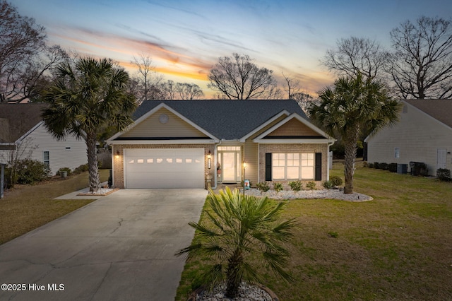 view of front facade featuring brick siding, a garage, concrete driveway, and a front lawn