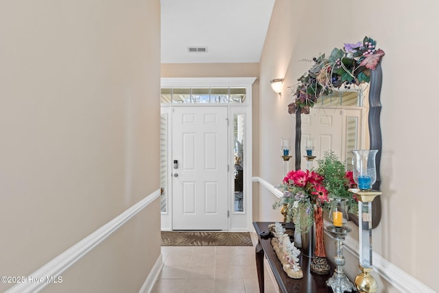 tiled foyer featuring visible vents and baseboards