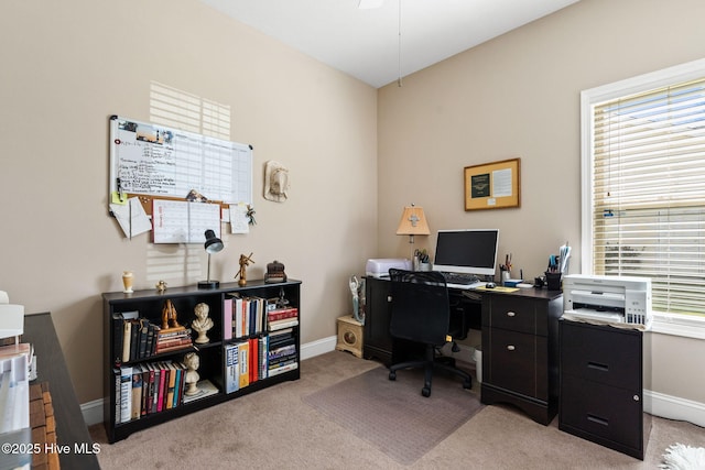 office featuring baseboards, plenty of natural light, and light carpet