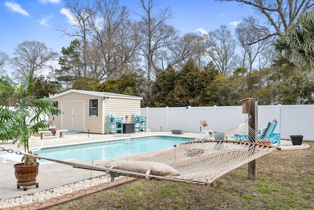 view of swimming pool with a fenced in pool, an outdoor structure, a fenced backyard, and a patio area