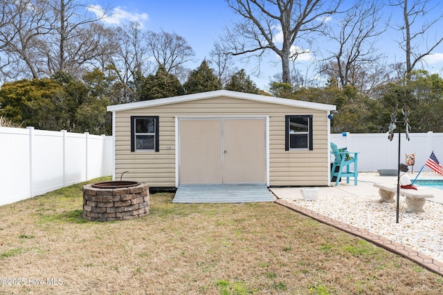 view of shed with a fenced backyard and an outdoor fire pit