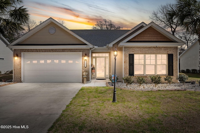 view of front of house with brick siding, a garage, a yard, and driveway