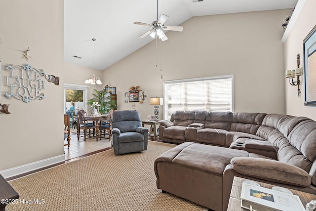 living room with visible vents, ceiling fan with notable chandelier, high vaulted ceiling, and baseboards