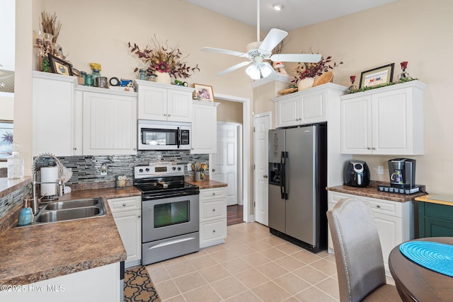 kitchen featuring a sink, stainless steel appliances, backsplash, and white cabinetry