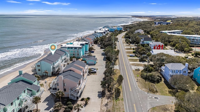 birds eye view of property with a water view and a beach view