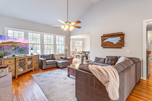 living room featuring a ceiling fan, high vaulted ceiling, and hardwood / wood-style flooring