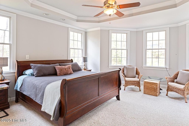 bedroom featuring ornamental molding, a raised ceiling, light carpet, and ceiling fan