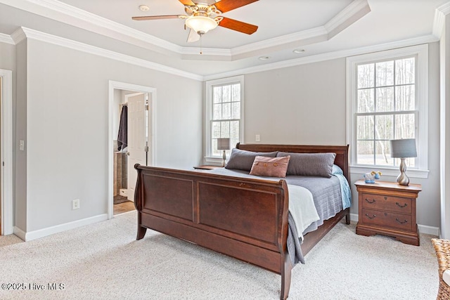 bedroom with carpet floors, a tray ceiling, crown molding, and baseboards