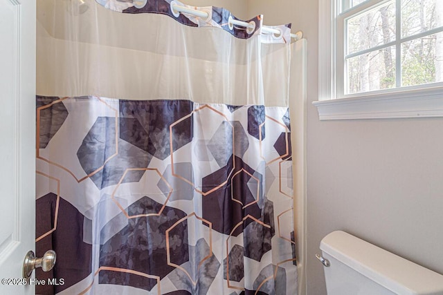 bathroom with toilet and curtained shower