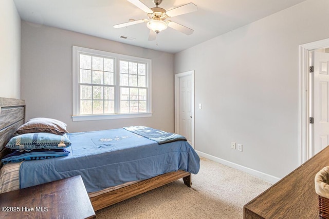 carpeted bedroom with a ceiling fan, visible vents, and baseboards