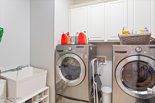 washroom featuring cabinet space, a sink, and independent washer and dryer