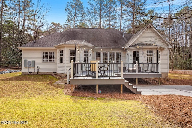 back of property with crawl space, roof with shingles, a lawn, and a deck