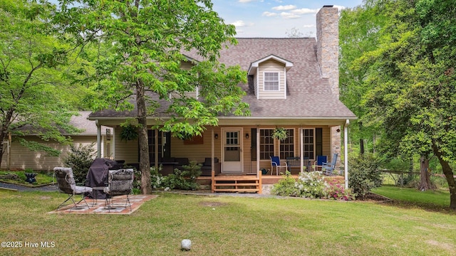 back of house with a lawn, a chimney, a shingled roof, and a porch