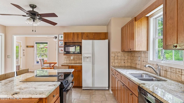 kitchen with a sink, decorative backsplash, a ceiling fan, and black appliances