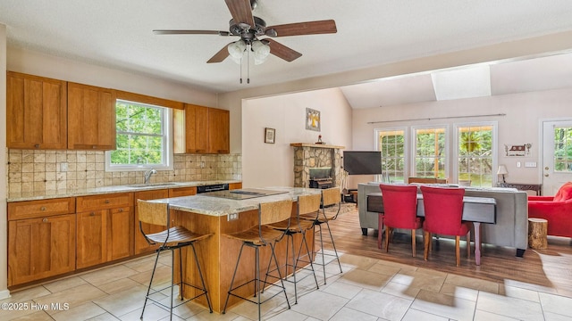 kitchen featuring brown cabinets, open floor plan, and decorative backsplash