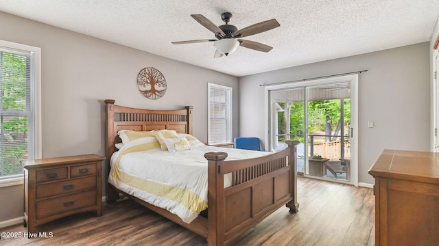 bedroom featuring access to exterior, wood finished floors, and multiple windows