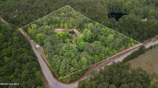 birds eye view of property with a forest view