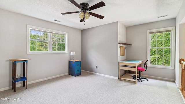 interior space with visible vents, a ceiling fan, a textured ceiling, and plenty of natural light