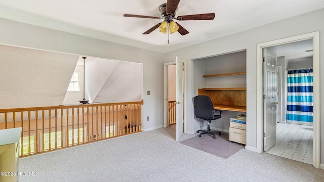 office area with baseboards, ceiling fan, carpet flooring, and a textured ceiling