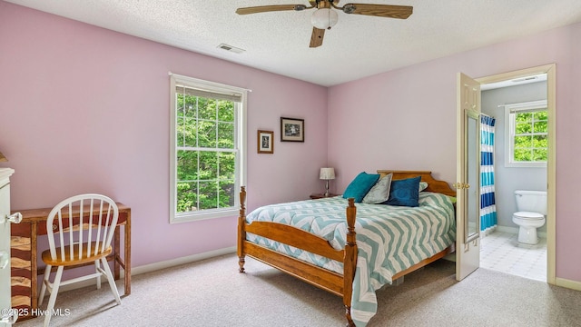 bedroom with visible vents, carpet flooring, baseboards, and connected bathroom