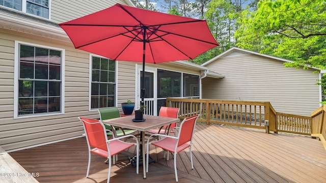deck featuring outdoor dining space and a sunroom