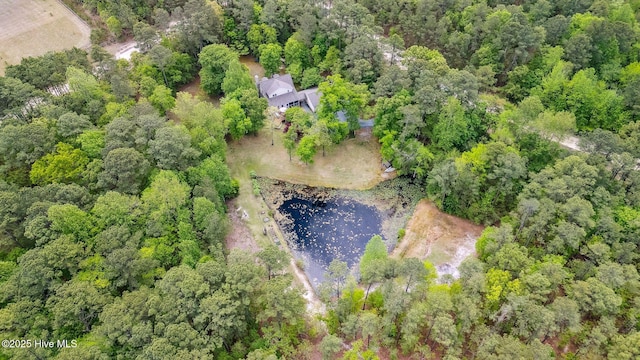 birds eye view of property featuring a forest view and a water view