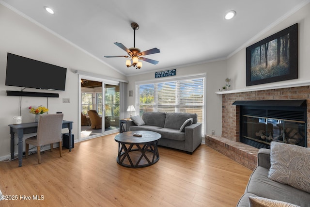 living area with light wood finished floors, a wealth of natural light, and lofted ceiling