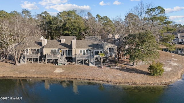 rear view of property with a deck with water view and stairway